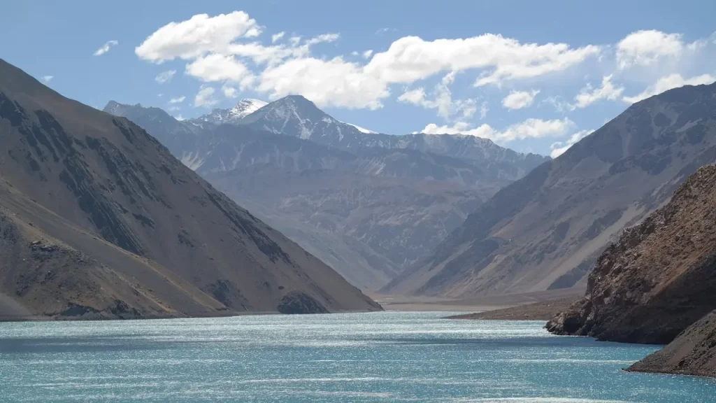 Vista da Laguna del Inca cercada por montanhas nevadas na Cordilheira dos Andes, em Valle Nevado, Chile.