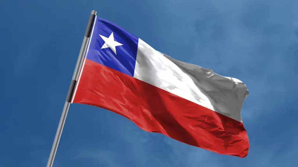 Bandeira do Chile tremulando sob um céu azul.