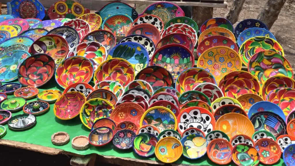 Artesanatos coloridos de cerâmica à venda em um mercado de San Pedro de Atacama, incluindo pratos e tigelas com design vibrante e temas tradicionais.