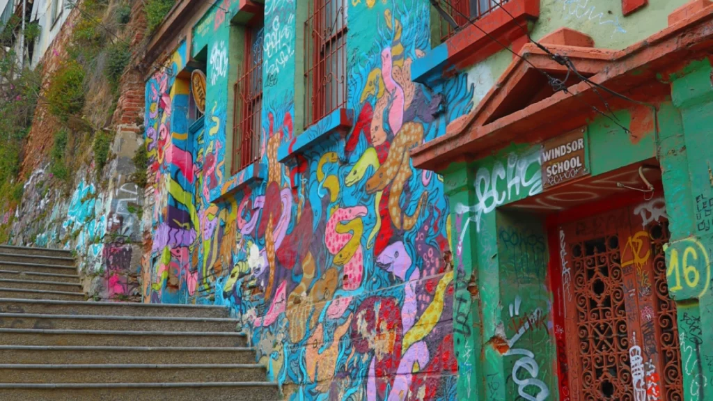 Mural colorido com arte urbana vibrante em uma parede no Museu a Céu Aberto, localizado no Cerro Bellavista, em Valparaíso.