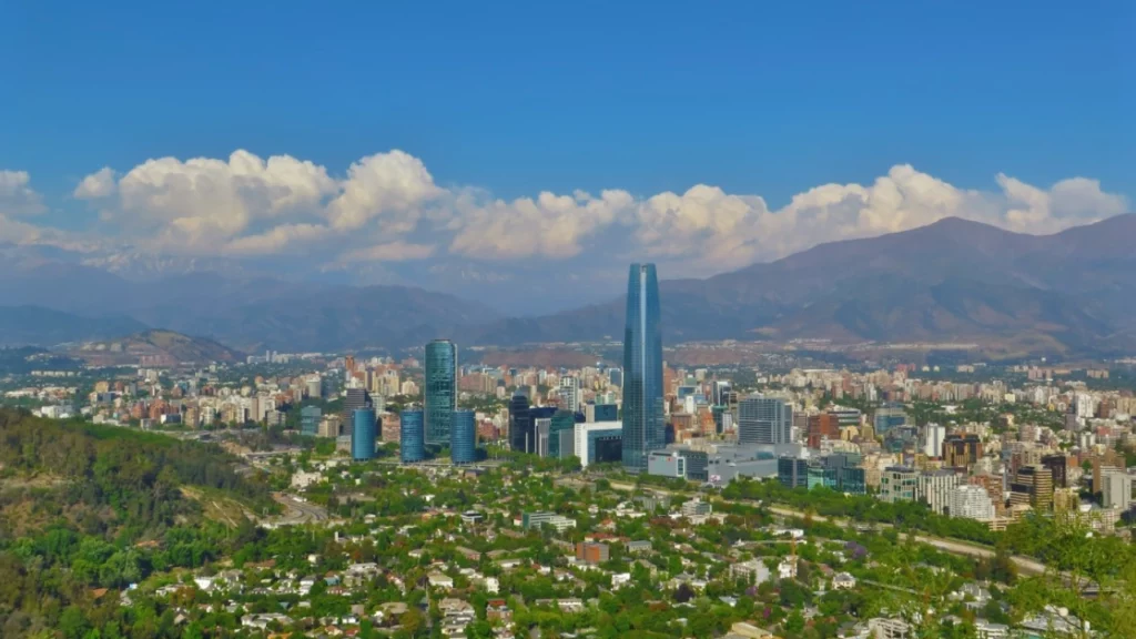 Vista panorâmica de Santiago, capital do Chile, com o imponente edifício Sky Costanera e a Cordilheira dos Andes ao fundo.