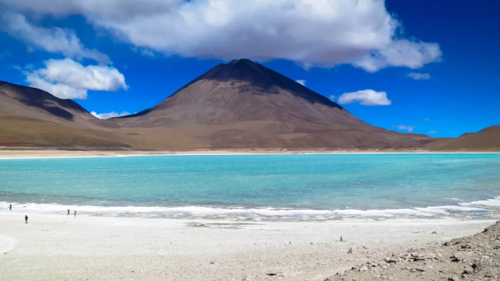 A encantadora Lagoa Altiplânica no Atacama, com suas águas azul-turquesa rodeadas por vulcões majestosos.