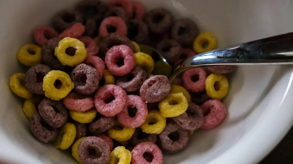 Tigela com cereais coloridos em formato de argola, ideal para um café da manhã criativo e divertido.