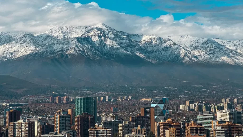 Paisagem de Santiago com as montanhas nevadas da Cordilheira dos Andes, destaque do inverno chileno.