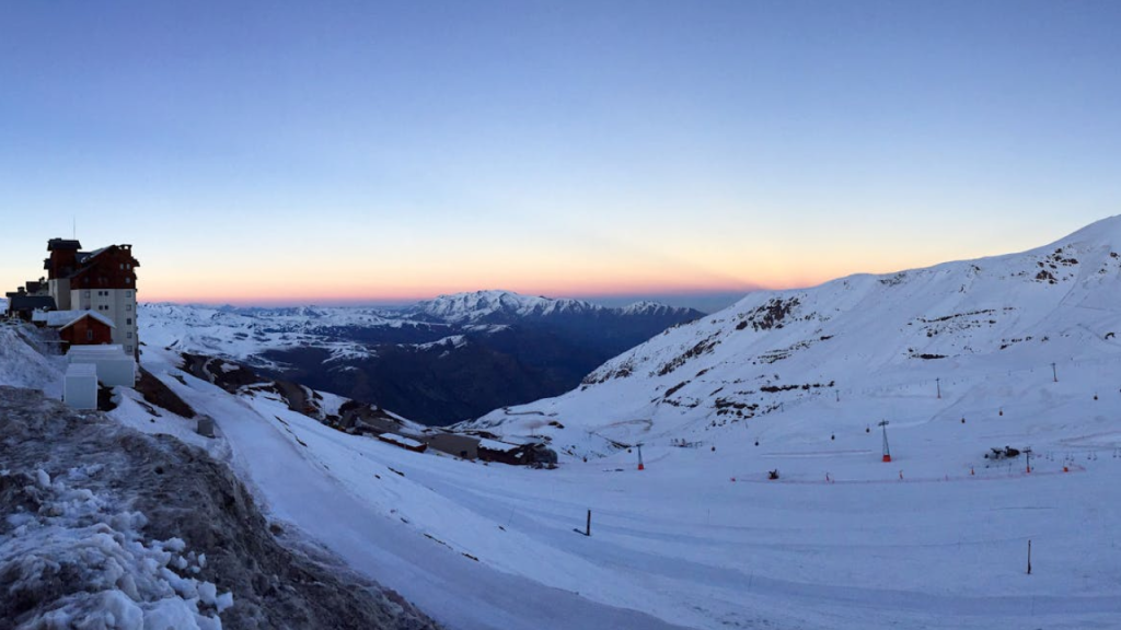 Panorama ao pôr do sol das pistas de ski nos Andes, ideal para quem quer conhecer a neve no Chile com vistas inesquecíveis.