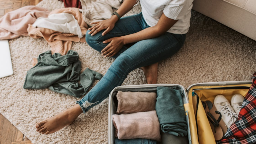 Viajante preparando mala com roupas de inverno para viagem ao Chile, com destaque para peças térmicas e casuais.