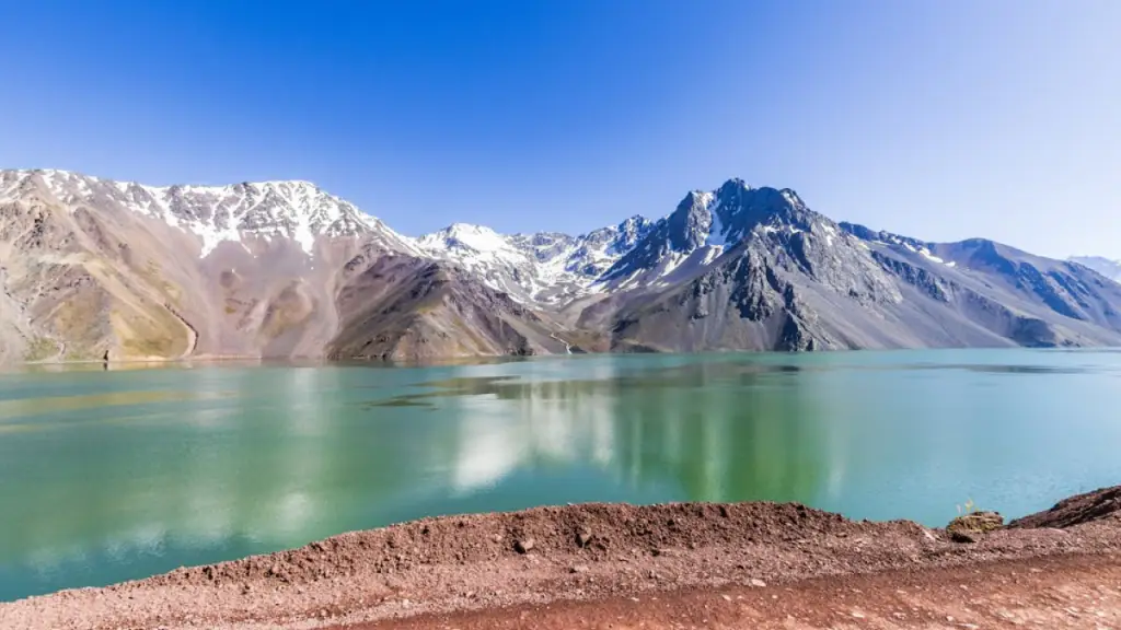 Embalse El Yeso no Cajón del Maipo, água esverdeada com picos nevados refletidos.